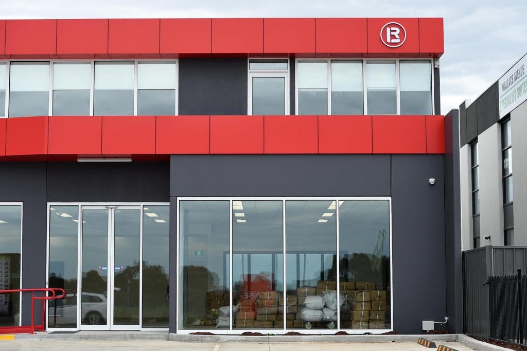 Red and grey precast concrete walls and large glass windows at front of Wanxi convenience store