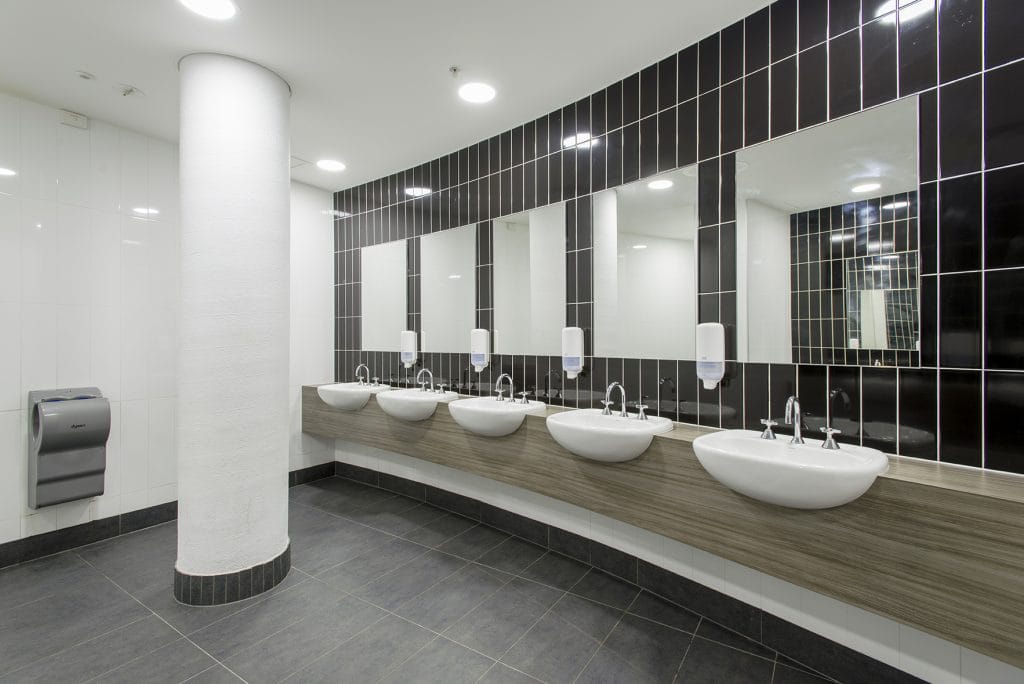 Brown tiles on wall with individual sinks in bathroom at Hisense area of Melbourne Park