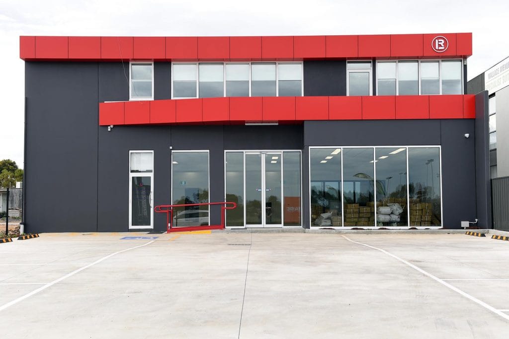 red and grey precast concrete walls and large glass windows at front of building